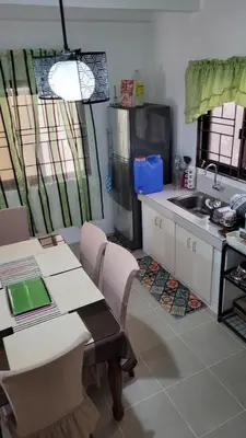 a kitchen with a table and a sink and a table and chairs at Camilyn Home Stay in General Trias