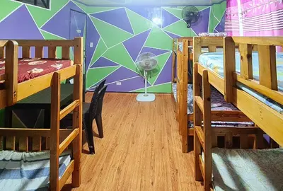 a dorm room with three bunk beds and a wall with a geometric design at Yuzons Bedspacer and Transient Home Staycation in Manila