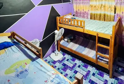 a bedroom with a bunk bed with a painting on the wall at Yuzons Bedspacer and Transient Home Staycation in Manila