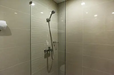 a shower in a bathroom with a glass door at Modern 1BR in Uptown BGC in Manila