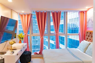 a bedroom with a bed and a large window at Modern 1BR in Uptown BGC in Manila