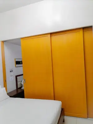 a room with a bed and a yellow closet at One Uptown Opposite of grandhyatt hotel manila Taguig city in Manila
