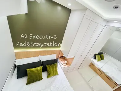 a room with a bed and two green pillows at A2 Executive Pad & Staycation in Manila