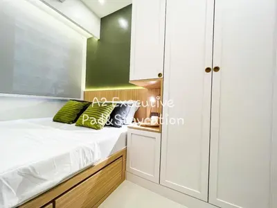 a small bedroom with white cabinets and green pillows at A2 Executive Pad & Staycation in Manila