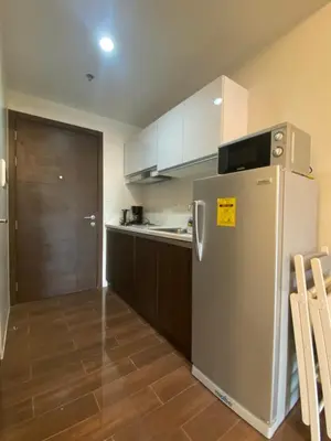 a kitchen with a stainless steel refrigerator and wooden cabinets at Air Residences 4439 in Manila