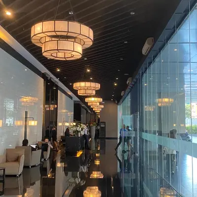 a lobby with tables and chairs and chandeliers at Air Residences 4439 in Manila