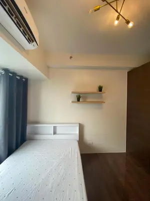 a bedroom with a white bed and a shelf at Air Residences 4439 in Manila