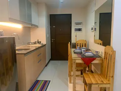 a kitchen with a table and chairs and a sink at 101 Newport condo in Pasay near airport in Manila