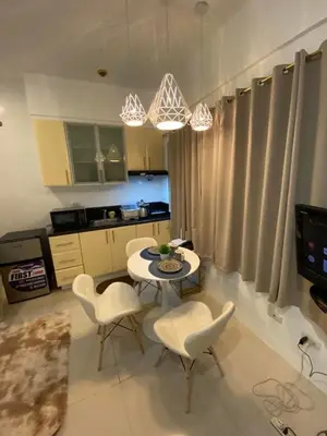 a kitchen with a table and chairs in a kitchen at Comfy Artsy Studio in BGC in Manila