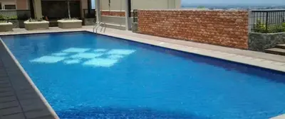 a large blue swimming pool in a building at Comfy Artsy Studio in BGC in Manila