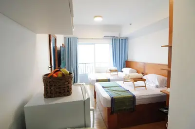 a room with two beds and a living room at R'Holistay Grace Taguig Fast Wifi Self Check In in Manila