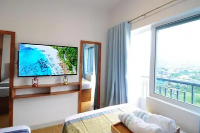 a hotel room with a tv and a large window at R'Holistay Grace Taguig Fast Wifi Self Check In in Manila
