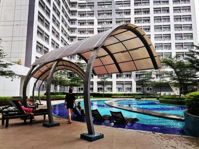 a woman standing in front of a pool with a canopy at R'Holistay Grace Taguig Fast Wifi Self Check In in Manila