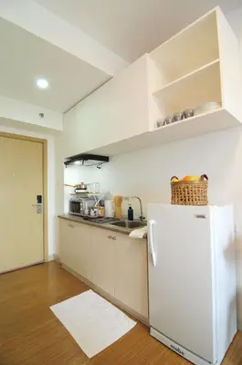 a kitchen with white cabinets and a white refrigerator at R'Holistay Grace Taguig Fast Wifi Self Check In in Manila