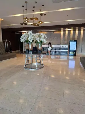 a lobby with two vases with flowers on a table at Shore Residences MOA by darpm in Manila