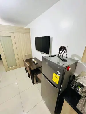 a living room with a small table and a television at Shore Residences MOA by darpm in Manila