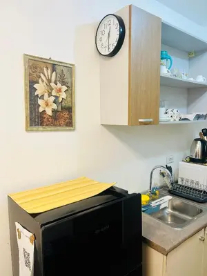 a kitchen with a microwave and a clock on the wall at 1BR Homy Furnished Unit Grace Residences Taguig in Manila