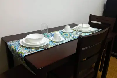 a table with plates and bowls and glasses on it at 1BR Homy Furnished Unit Grace Residences Taguig in Manila