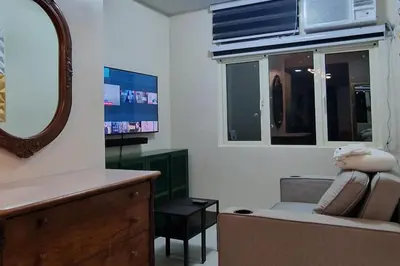 a living room with a couch and a mirror at 1 Bed Apartment Sleeps 2 with Parking in Manila