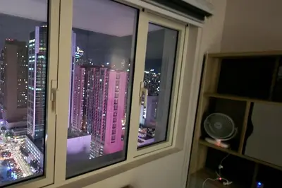 a window with a view of a city at night at 1 Bed Apartment Sleeps 2 with Parking in Manila