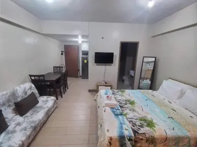 a hotel room with a bed and a couch at Palmtree Villas Two Condotel Near Airport in Manila