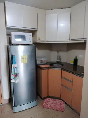 a kitchen with a stainless steel refrigerator and a microwave at Palmtree Villas Two Condotel Near Airport in Manila