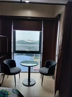 a room with a table and two chairs and a window at Palmtree Villas Two Condotel Near Airport in Manila