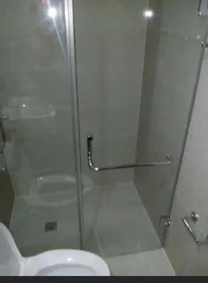 a glass shower door in a bathroom with a toilet at Transient Near Airport by Rqui in Manila