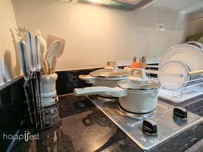a kitchen with three pots and pans on a stove at Happirest at Shore 3 Residences with Balcony, Mall of Asia in Manila