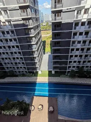 two tall buildings next to a swimming pool at Happirest at Shore 3 Residences with Balcony, Mall of Asia in Manila