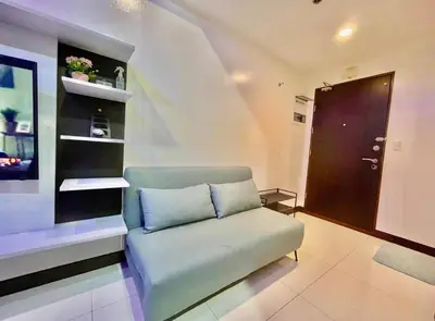 a living room with a couch and a staircase at Luxury 1BR Unit with Pool at Venice Luxury Residences, Tower Domenico, McKinley Hill, Taguig City in Manila