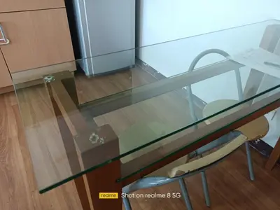 a glass table with a chair in a room at WestParc Cedar Alabang in Manila