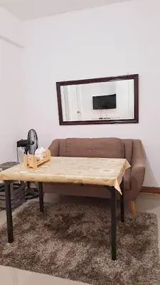 a coffee table in front of a couch with a mirror at Night Blink Staycation And Rentals in Cainta