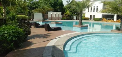 a large swimming pool with chairs next to a building at Night Blink Staycation And Rentals in Cainta