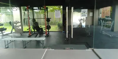 a gym with a person doing squats in a mirror at Night Blink Staycation And Rentals in Cainta