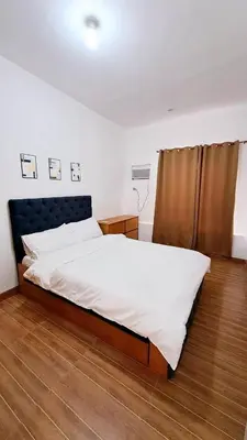 a bedroom with a large bed with white sheets at Night Blink Staycation And Rentals in Cainta