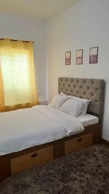 a bedroom with a large bed and a window at Night Blink Staycation And Rentals in Cainta