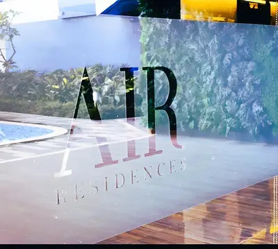 a reflection of a business sign in a window at Air Residences Condominium Deluxe in Manila