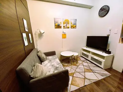 a living room with a couch and a flat screen tv at Air Residences Condominium Deluxe in Manila