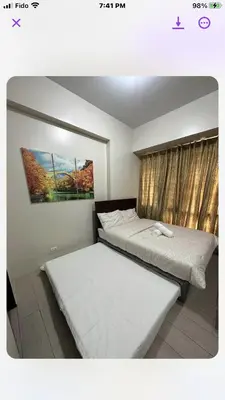 a bedroom with two beds and a painting on the wall at Robles’ Unit at 81 Newport Boulevard in Manila