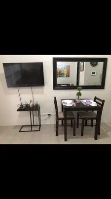a dining room with a table and chairs and a television at Robles’ Unit at 81 Newport Boulevard in Manila