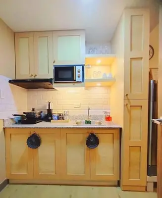 a kitchen with a sink and a microwave at Spring Residences Scandinavian 2 bedrooms with balcony Near NAIA in Manila