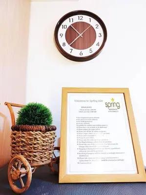 a clock on a wall next to a basket with a plant at Spring Residences Scandinavian 2 bedrooms with balcony Near NAIA in Manila