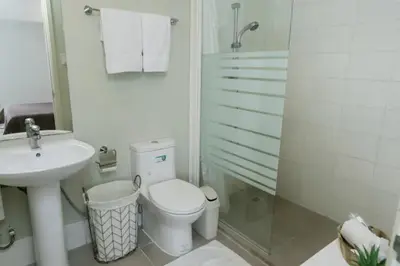 a bathroom with a toilet and a sink and a shower at BGC Private Apartments in Manila
