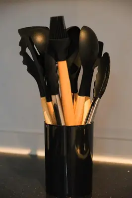 a black cup filled with different types of utensils at BGC Private Apartments in Manila