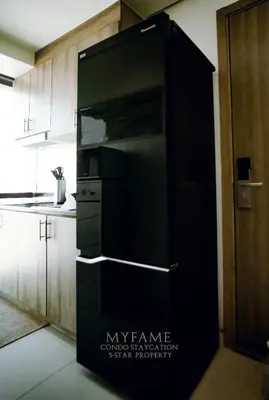 a large black refrigerator in a kitchen with white cabinets at 2BR SMDC Premium Unit: FAME Residences 31st FLOOR in Manila