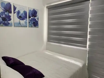 a bedroom with a window with two paintings on the wall at Katei elegantly designed 1-bedroom facing amenity in Manila