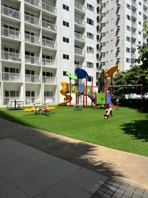 a playground in front of a large apartment building at Katei elegantly designed 1-bedroom facing amenity in Manila