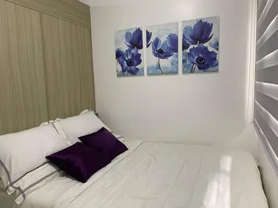 a white bed with purple pillows in a room at Katei elegantly designed 1-bedroom facing amenity in Manila