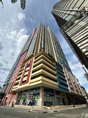 a tall building with many windows on a city street at Grand Riviera Suits in Manila